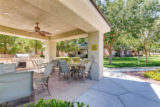 view of patio / terrace featuring area for grilling, ceiling fan, and exterior kitchen