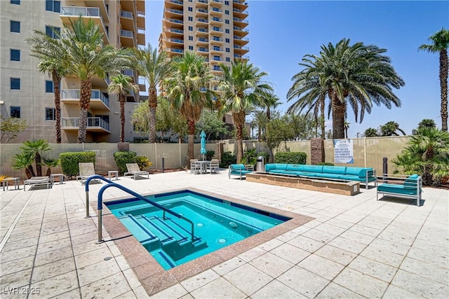 view of swimming pool featuring a community hot tub and a patio area