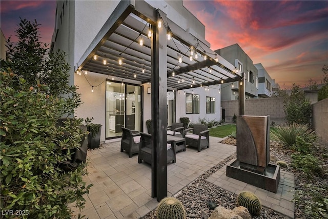 patio terrace at dusk with outdoor lounge area and a pergola