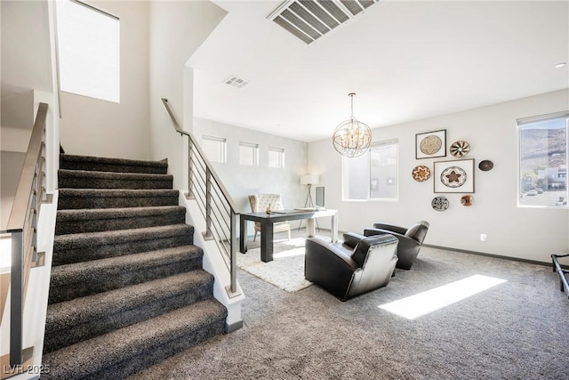 living room featuring a healthy amount of sunlight, carpet flooring, and a notable chandelier