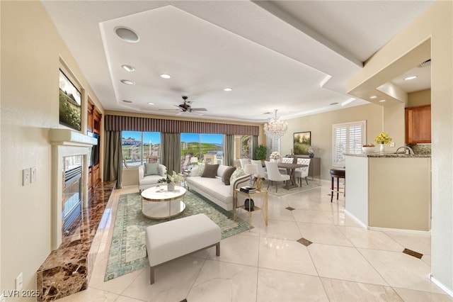 living room with light tile patterned flooring and ceiling fan with notable chandelier