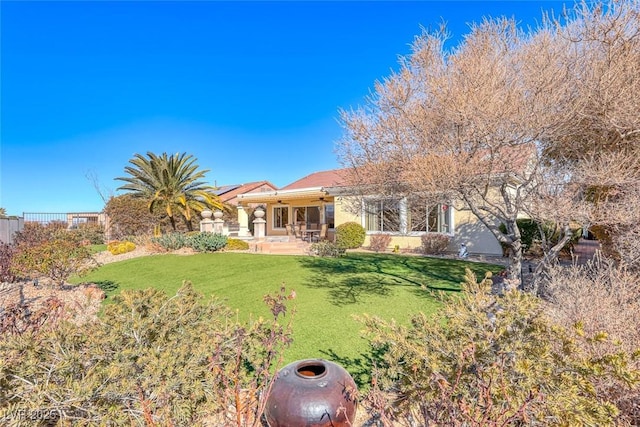 rear view of house with a lawn and a patio