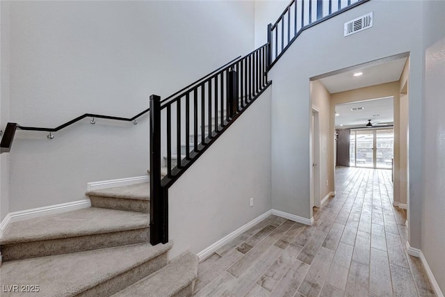 stairs featuring wood-type flooring and ceiling fan