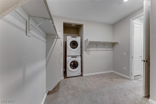 clothes washing area with light colored carpet and stacked washing maching and dryer