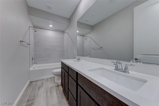 full bathroom featuring tiled shower / bath combo, vanity, and toilet