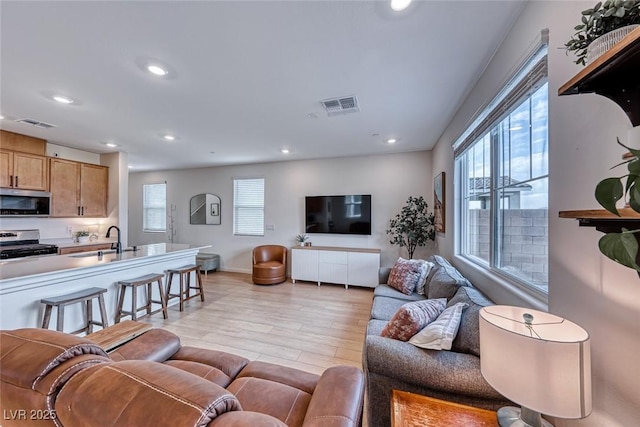 living room featuring sink and light wood-type flooring