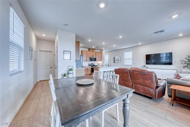 dining space featuring sink and light hardwood / wood-style flooring