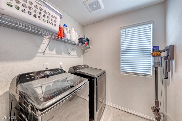 laundry area with light tile patterned floors and washer and dryer