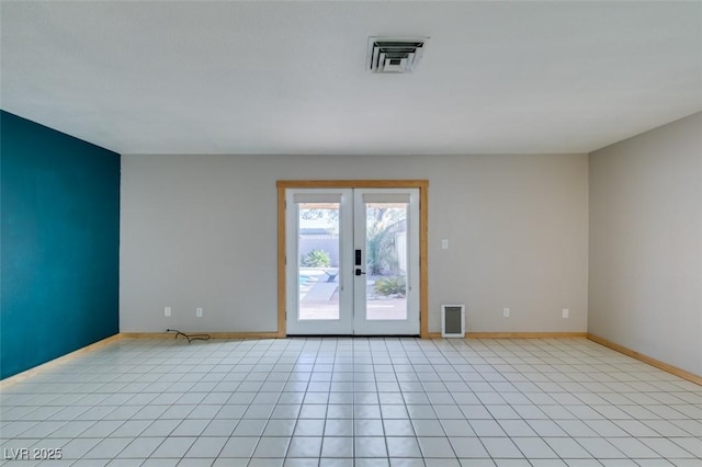 spare room with french doors and light tile patterned flooring