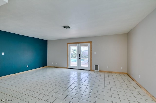 spare room featuring light tile patterned flooring and french doors