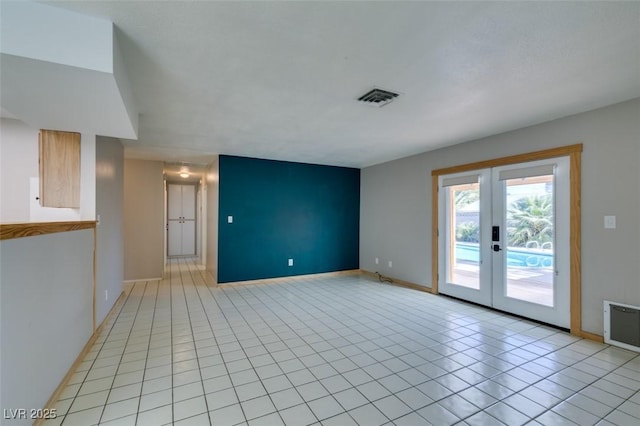 unfurnished living room featuring light tile patterned floors and french doors