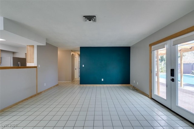 unfurnished living room with light tile patterned flooring and french doors