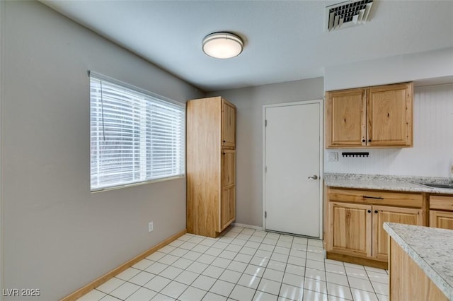 kitchen featuring sink, light tile patterned floors, and light brown cabinetry