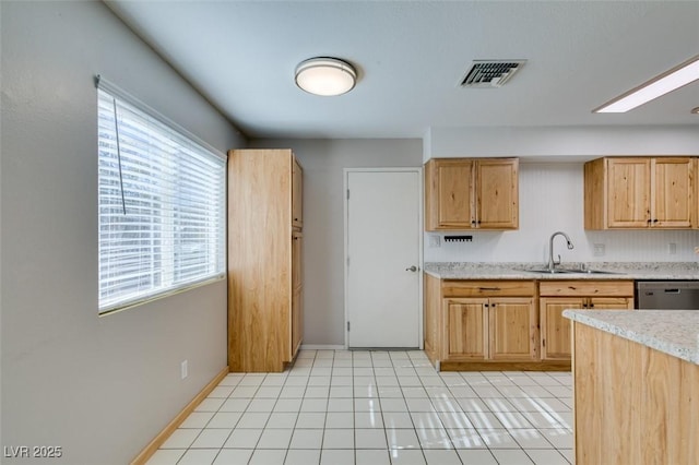 kitchen with light tile patterned flooring, light brown cabinetry, dishwasher, and sink