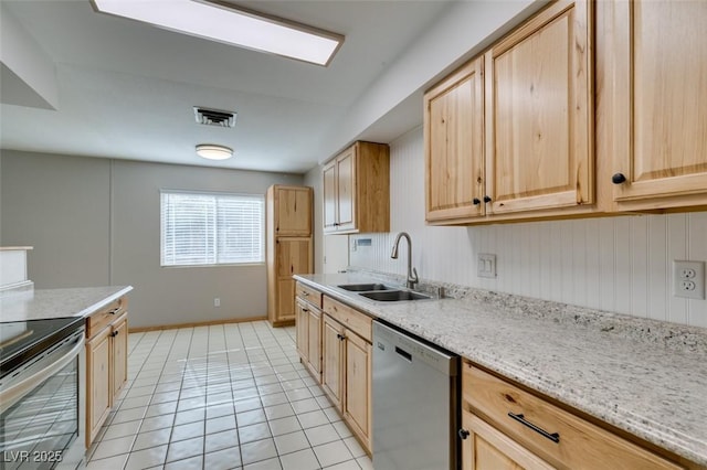 kitchen with light tile patterned flooring, light brown cabinetry, sink, stainless steel appliances, and light stone countertops