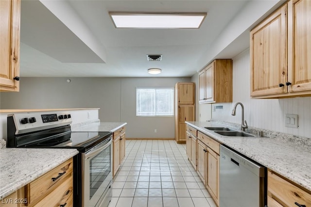 kitchen with sink, stainless steel appliances, light stone counters, light tile patterned flooring, and light brown cabinetry