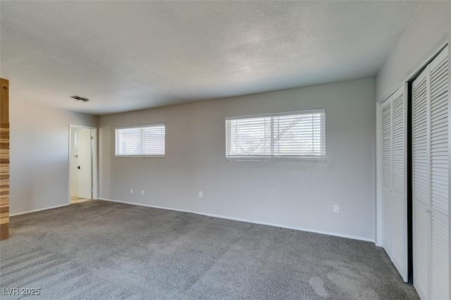 interior space featuring a closet, a textured ceiling, and carpet