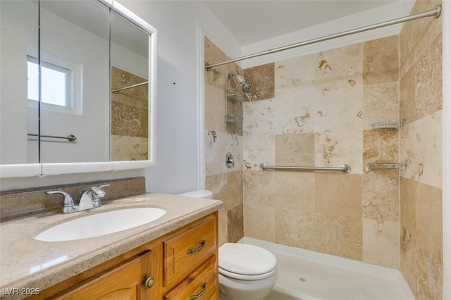 bathroom with vanity, toilet, and a tile shower