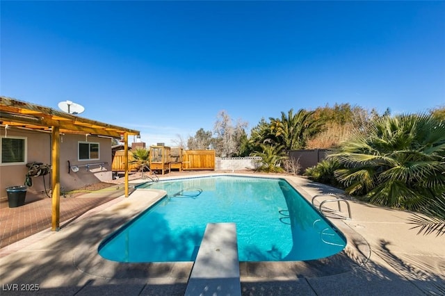 view of pool with a diving board and a patio area