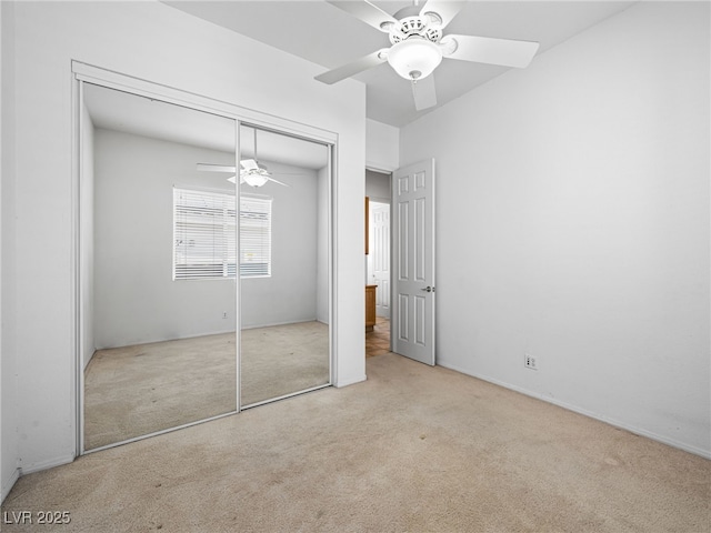 unfurnished bedroom with light carpet, ceiling fan, and a closet