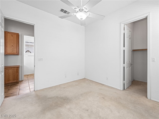 unfurnished bedroom with light colored carpet, a closet, and ceiling fan