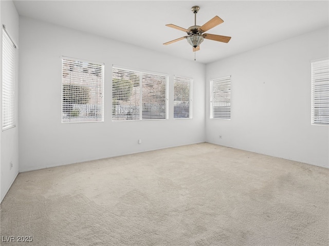 carpeted empty room featuring ceiling fan and plenty of natural light