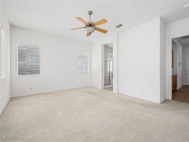 spare room with ceiling fan and light colored carpet