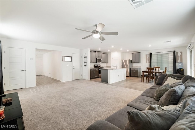 carpeted living room with sink and ceiling fan