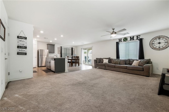 carpeted living room with ceiling fan