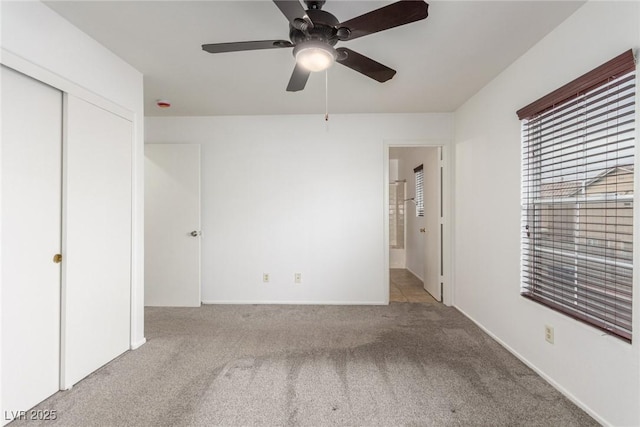 unfurnished bedroom with light colored carpet, ceiling fan, and a closet