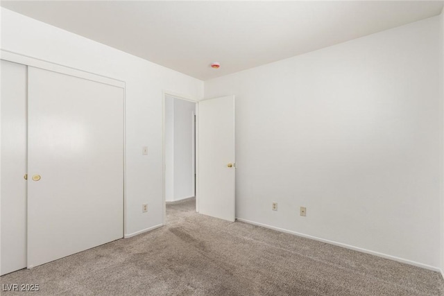 unfurnished bedroom with light carpet and a closet