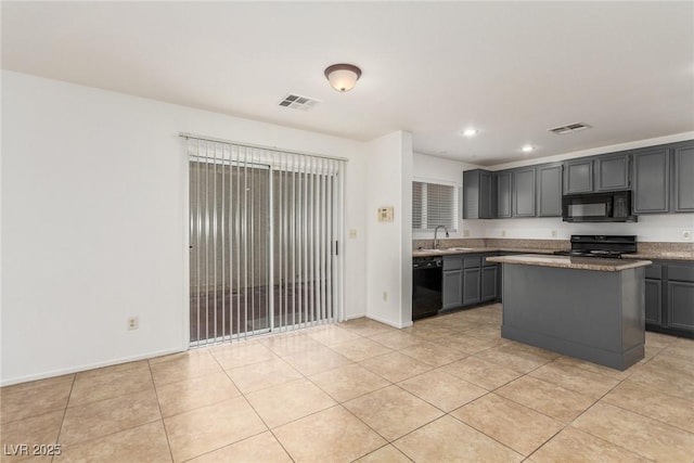 kitchen with sink, gray cabinets, a center island, black appliances, and light tile patterned flooring