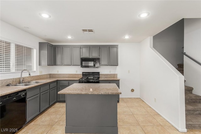 kitchen featuring light tile patterned flooring, sink, gray cabinetry, a center island, and black appliances