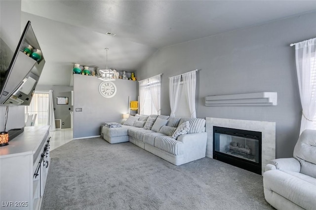 living room with light carpet, a notable chandelier, vaulted ceiling, and plenty of natural light