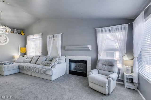 living room featuring an AC wall unit, lofted ceiling, carpet, and a fireplace