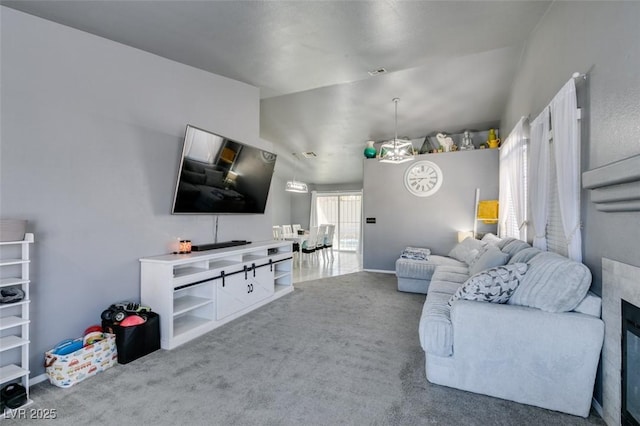 living room featuring a notable chandelier, vaulted ceiling, and carpet flooring