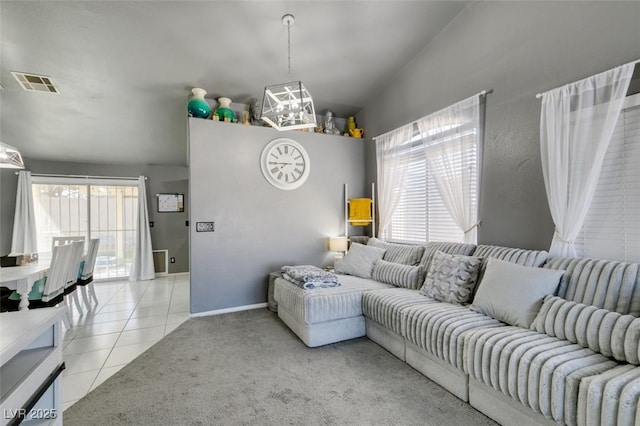 tiled living room featuring vaulted ceiling, plenty of natural light, and an inviting chandelier