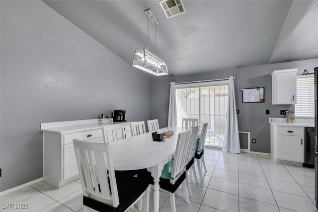 tiled dining room featuring vaulted ceiling and a healthy amount of sunlight