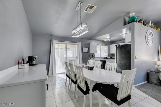 tiled dining space with lofted ceiling