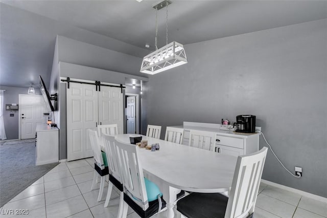 dining space with a barn door, vaulted ceiling, and light carpet