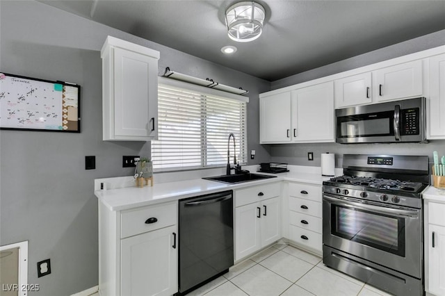 kitchen with white cabinetry, sink, stainless steel appliances, and light tile patterned flooring