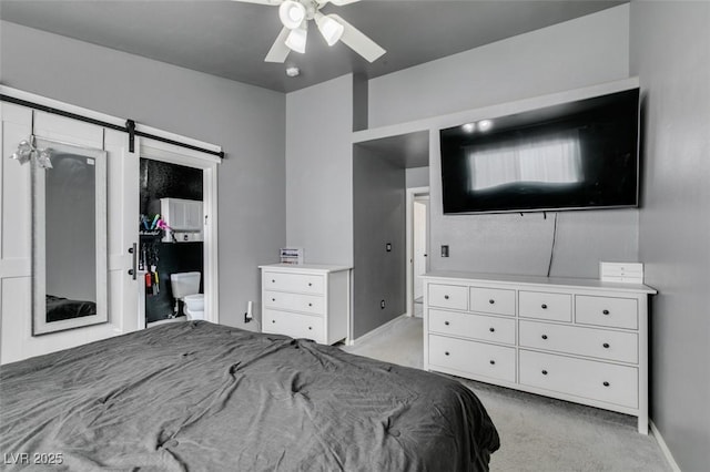 bedroom with a barn door, light colored carpet, and ceiling fan