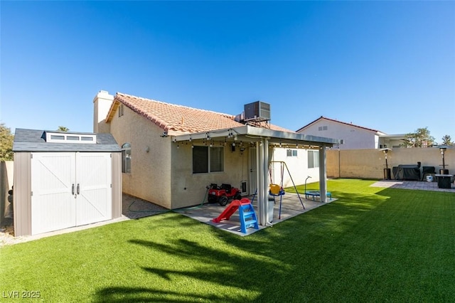 rear view of property featuring a storage shed, central air condition unit, a patio area, and a lawn