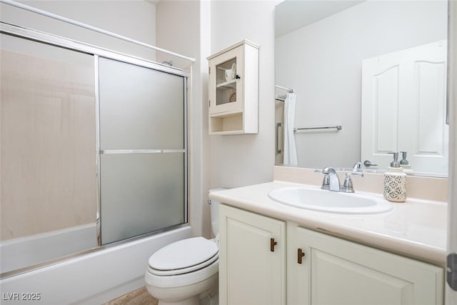 full bathroom with vanity, toilet, and combined bath / shower with glass door