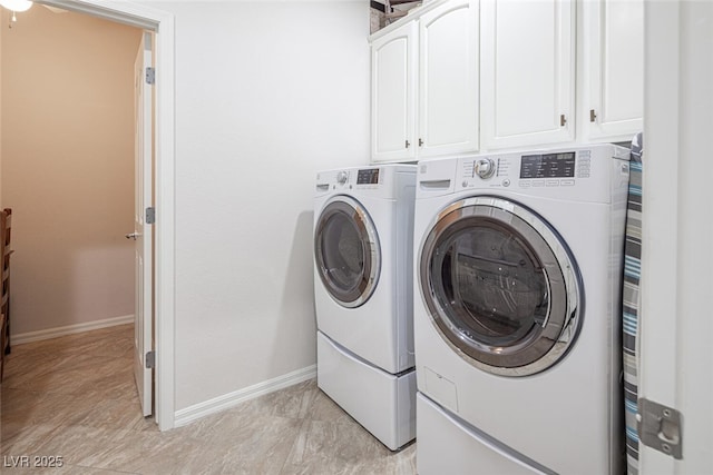 washroom with cabinets and washing machine and clothes dryer