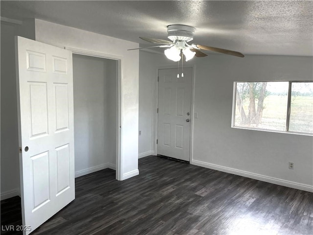 unfurnished bedroom with dark wood-type flooring, a textured ceiling, ceiling fan, and a closet