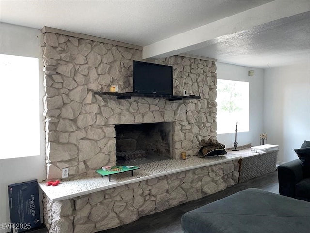 living room featuring a stone fireplace and a textured ceiling
