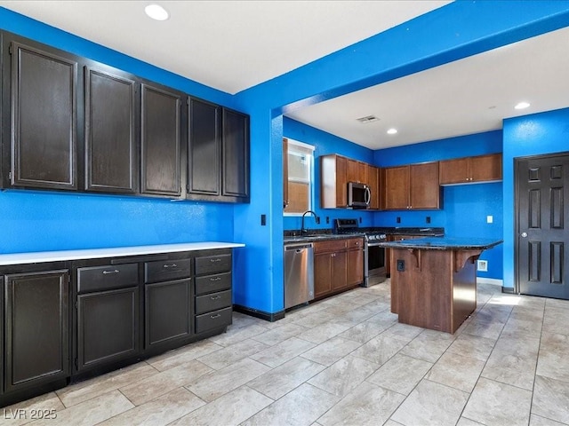 kitchen with recessed lighting, stainless steel appliances, a kitchen island, visible vents, and baseboards