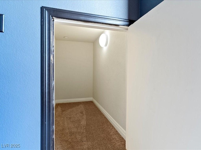 hallway featuring carpet floors and baseboards