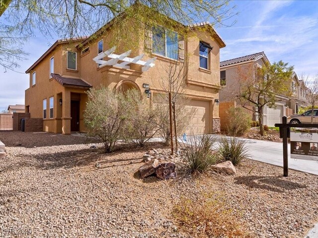 view of front facade with a garage, concrete driveway, and stucco siding